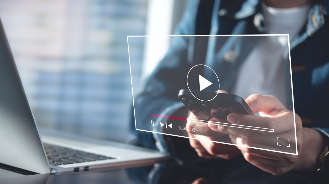Person schaut sich ein Online-Video auf dem Smartphone an – effektives Videomarketing für Social Media und Websites.